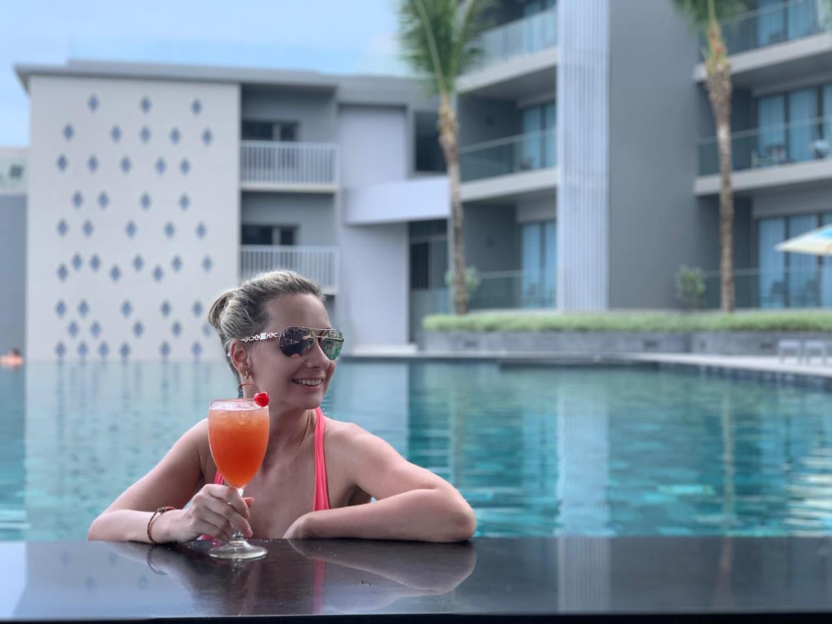 Oceanfront Beach Resort - Sha Extra Plus Patong Exterior foto A woman at a pool in Phuket, Thailand